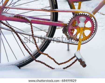 detail of colorful bicycle with broken chain in snow