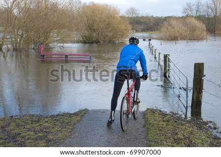 mountain biker in doubt in front of a flooded area