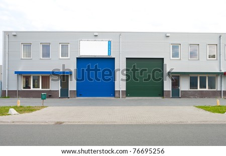 double office building with blue and green roller doors