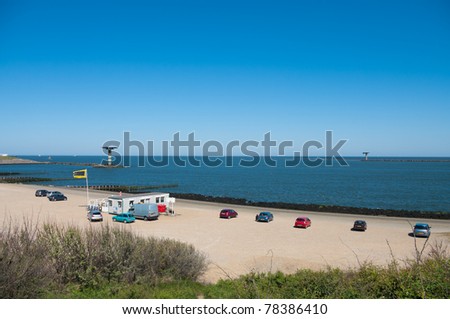 snack bar and parked cars on beach at the entrance of the port of Rotterdam
