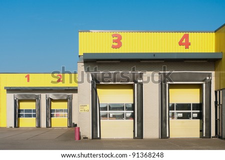 yellow industrial warehouse with numbered loading docks