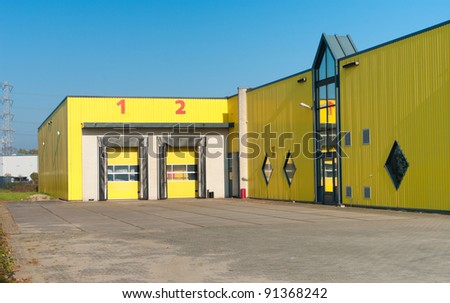 yellow industrial warehouse with numbered loading docks