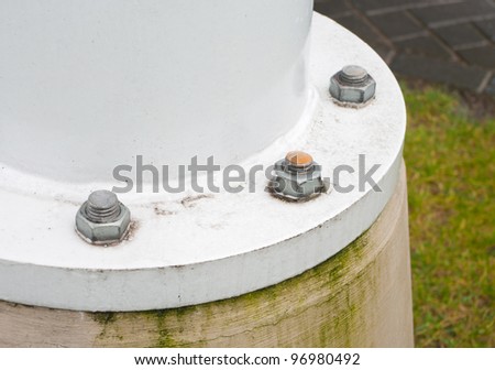 metal pillar fixed with bolts on a concrete foundation