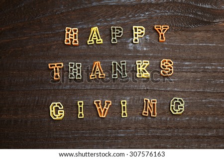 HAPPY THANKS GIVING, Greeting message in colorful alphabet pasta on wood background