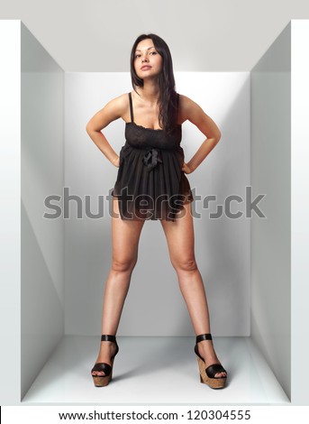beautiful woman fits on a black dress in fitting-room