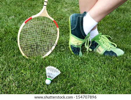 foot of badminton player who stays on grass