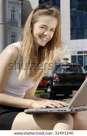 happy student with laptop computer near the modern building