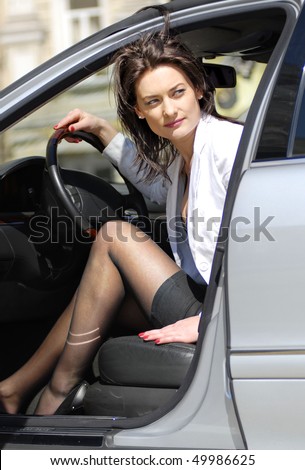 brunette woman looks round and parks the car back