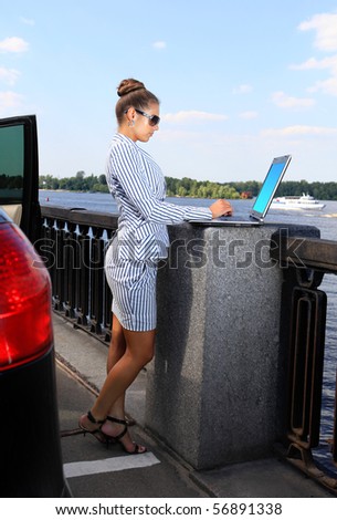 beautiful business woman with the laptop on city quay