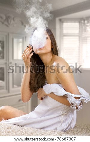 woman in prom dress smokes cigaret after farewell party