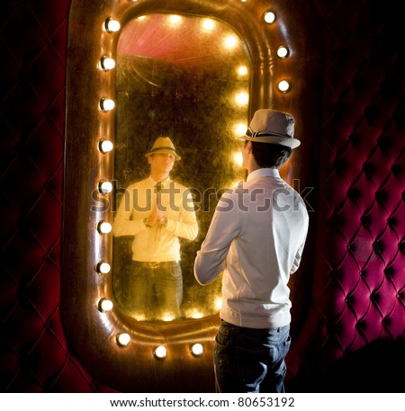retro young man looks at himself in mirror