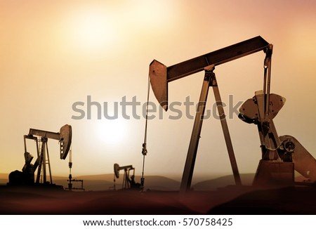 retro oil pumps in deserted district at sunset