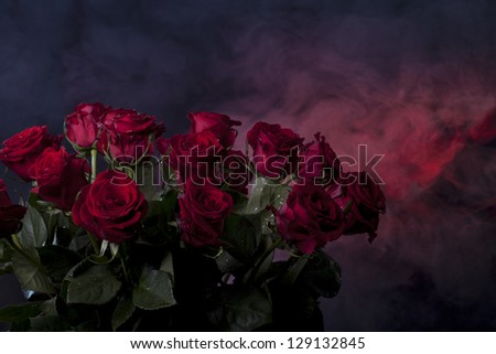 bouquet of red roses is on a dark colored background