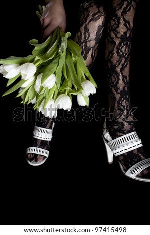 woman legs  in white shoes with flowers, isolated on a black