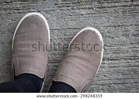 Canvas shoes walking on floor top view grey