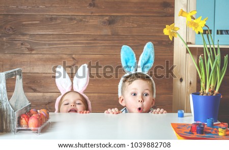Having fun on Easter egg hunt. Child boy and girl wearing bunny ears and painting eggs. colorful eggs.