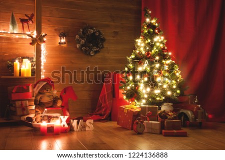 Christmas and New Year decorated interior room. Holiday decorated room with bed on window sill. Festive Xmas night with lights on tree with presents. Magic night with gifts