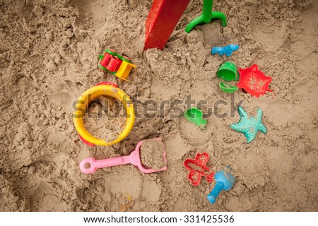 Bright plastic children toys in sandpit or on a beach