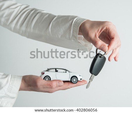 Hand with keys and car on white background. Car insurance. Automobile collision damage waiver concepts. with protective gesture and icon of car. Protection of car. Business concept.