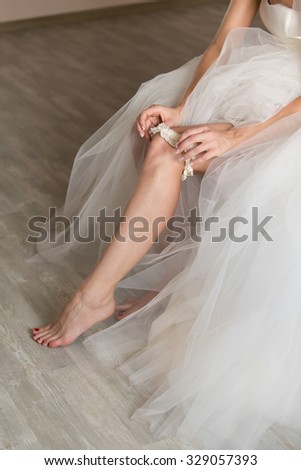 the bride in a wedding dress on an elegant dress garter leg