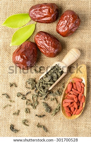 dried date fruit and tea, on the linen tablecloth, top view