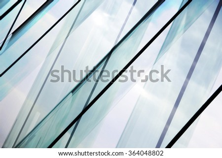 Glass architecture. Tilt double exposure photo of modern office building facade. Sample of dynamic business cityscape. Abstract high-technology composition with all-over glazing.