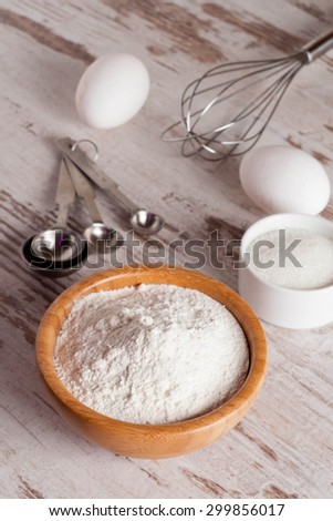ingredients and tools to make a cake, flour, sugar,eggs, vertical, close up