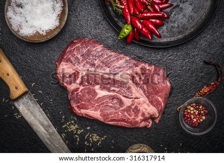 fresh raw steak with red pepper salt pan carving knife on a dark rustic background top view close up