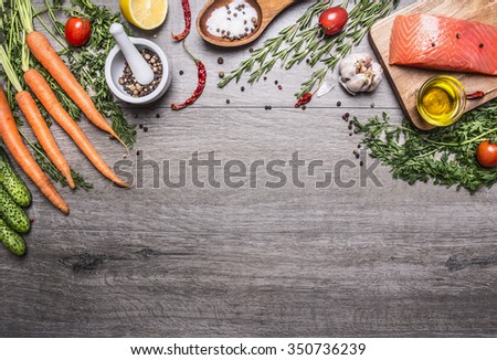 Salmon fillet with delicious ingredients for cooking a variety of vegetables and herbs, salt in the wooden spoon, cherry tomatoes, peppers, lemon on wooden rustic background top view place text,frame