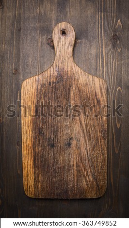 old vintage wooden cutting board  on wooden rustic background top view close up