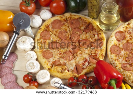 A couple of delicious pizzas, with raw tomatoes, green peppers and salami