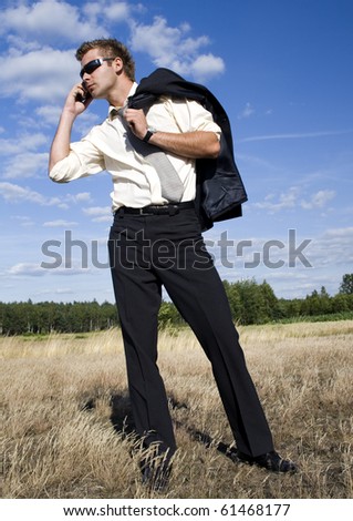A businessman dressed in a smart suit standing on grass