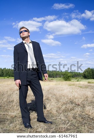 A businessman dressed in a smart suit standing on grass