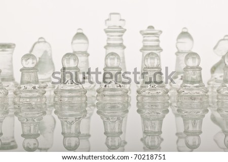 Beautiful glass chess on a white background. Photo taken in the studio on a glass countertop.