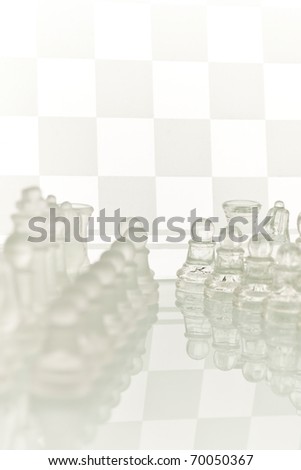 Beautiful glass chess on a white background. Photo taken in the studio on a glass countertop. Checkerboard is the background image.