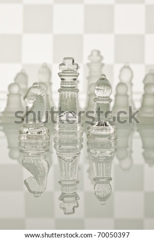 Beautiful glass chess on a white background. Photo taken in the studio on a glass countertop. Checkerboard is the background image.