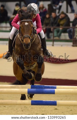 KAPOSVAR, HUNGARY - MARCH 24: Rebeka Marko jumps with her horse (Game Boy 4) on the Masters Tournament International Jumping Competition, March 24, 2013 in Kaposvar, Hungary