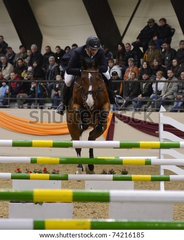 KAPOSVAR, HUNGARY - MARCH 27: Atttila Cser jumps with his horse (Laura) on the Masters Tournament International Jumping Competition, March 27, 2011 in Kaposvar, Hungary