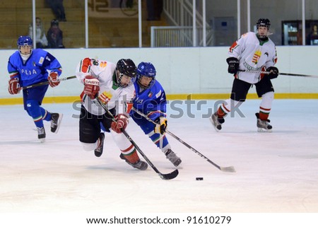 KAPOSVAR, HUNGARY - DECEMBER 17: Unidentified players in action at a friendly ice hockey match with Hungarian (white) and Italian (blue) Under 16 National Team, December 17, 2011 in Kaposvar, Hungary.