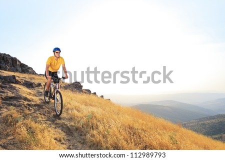 A young male riding a mountain bike on a sunset, Macedonia