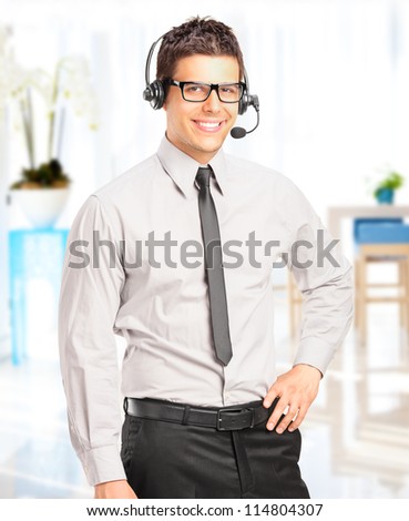 Handsome male customer service operator with headset posing in his office