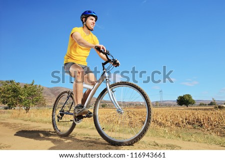 Panning shot of a person riding a bike outdoors with some motion blur shot with a tilt and shift lens