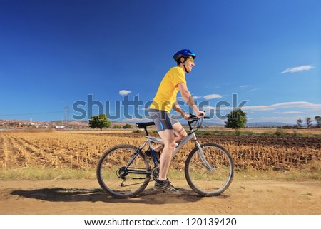 Biker in yellow shirt riding a bike on a sunny day