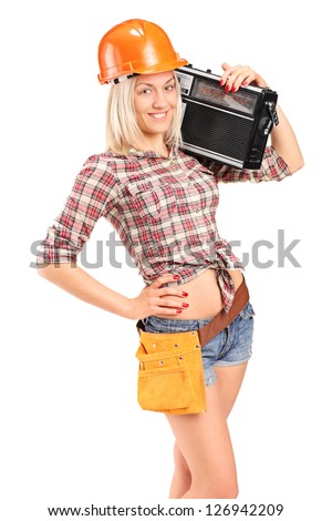 Smiling female worker with helmet listening to radio isolated on white background