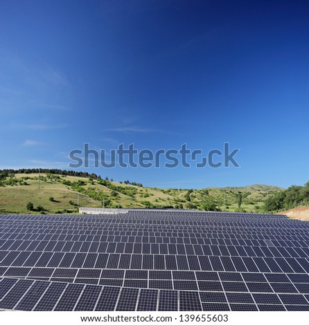 Solar photovoltaic cell panels on field under blue sky, Macedonia, shot with a tilt and shift lens