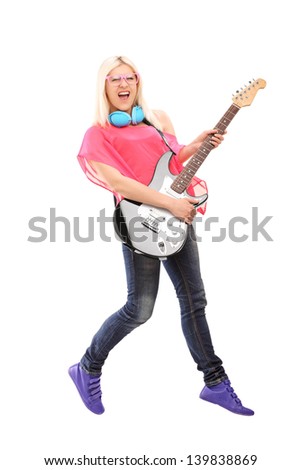 Full length portrait of a female rock star jumping and  playing a guitar, isolated on white background