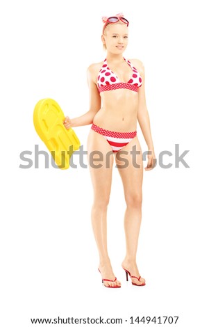 Full length portrait of a sexy female in bikini holding a yellow swimming float, isolated on white background
