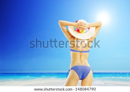 Attractive blond woman in bikini on a beach, enjoying the sun