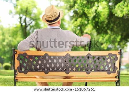 Mature man resting on a wooden bench in park