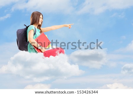 Young female student with school bag pointing with her finger and sitting on a cloud